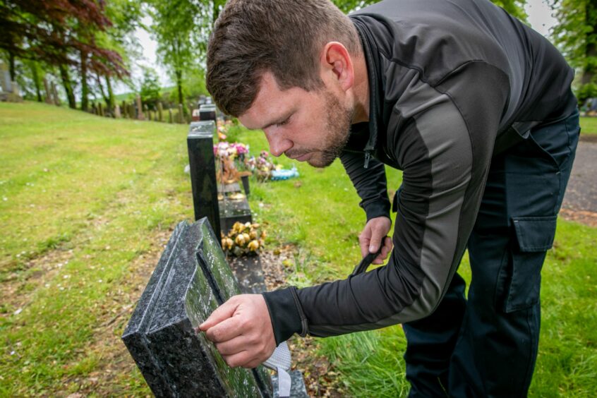 Headstone cleaner Andrew hard at work at Douglas Bank Cemetery in Rosyth. Image: Steve Brown/DC Thomson.