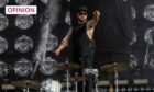 Royal Blood drummer Ben Thatcher pointing at the crowd from the stage.