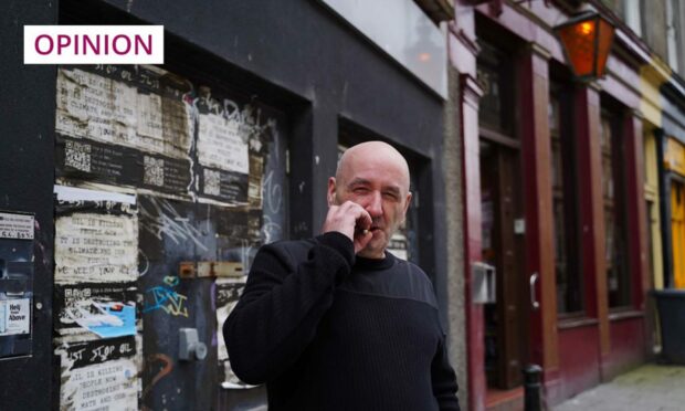 David Blair smoking a cigarette outside a Dundee pub.