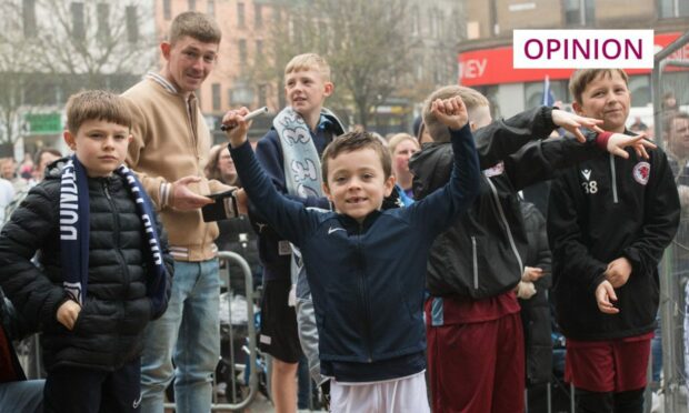 Group of young boys in Dundee scarves punching the air in celebration