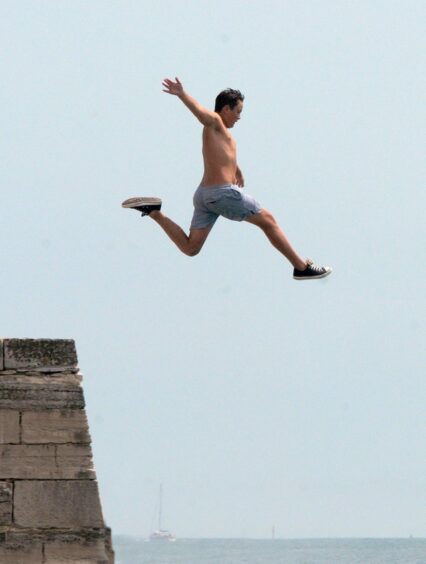 A boy tombstoning off a sea wall in Portsmouth.