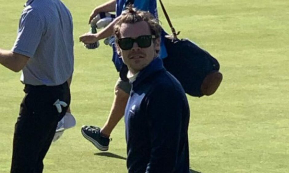 Harry Styles looking straight at the camera during a round on the Old Course
