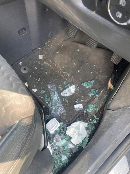 Image shows glass scattered all over the floor of Kerry's car