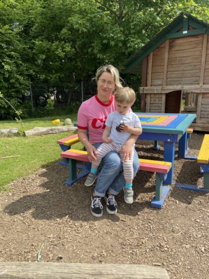 UHI student Katarzyma Bolesta sitting on a bench with her son Teo Wolymski -who attends the nursery - in the nursery garden.