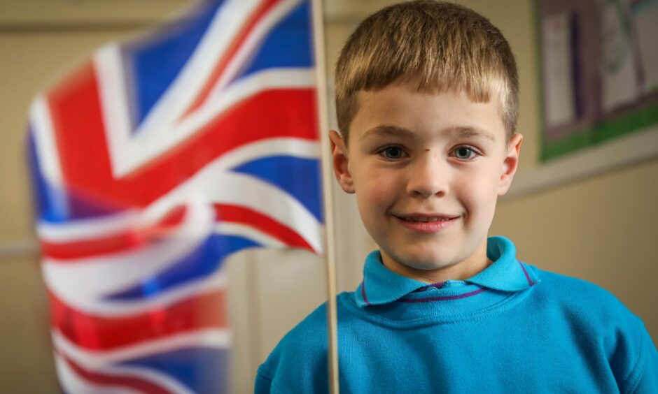 Mason Oram, aged 6, of Dundee Beavers waving a Union Jack flag.