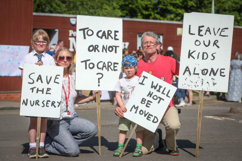 Betty Thompson, Rachel Chanarin, Sonny Thompson and Gregor Thompson all holding signs at the protest against the closure of the college nursery. 
