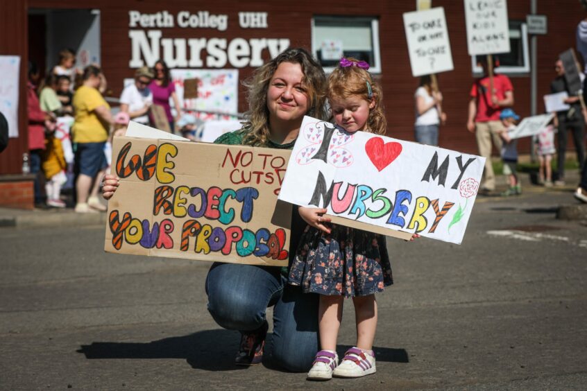 Justyna Grajewska and her daughter Julia at the Perth protest. Justyna is holding a "we reject your proposal" sign and Julia is holding a "I love my nursery" sign.