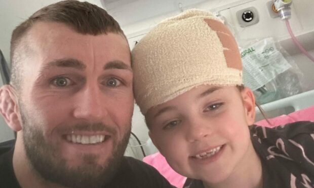 Stevie Ray with daughter Myla, who has a bandage on her head after surgery