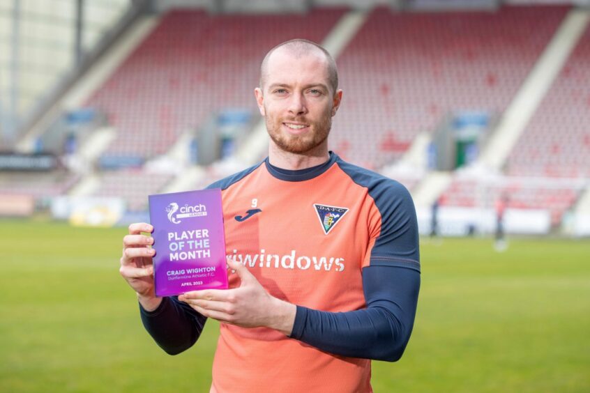 Craig Wighton holds up his League One player of the month award for April 2023.