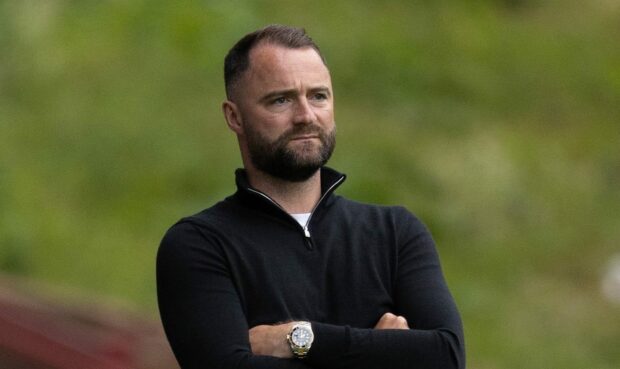 Dunfermline manager James McPake watches on.