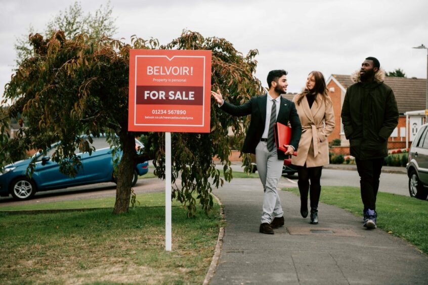 an agent shows a house on sale to a couple 