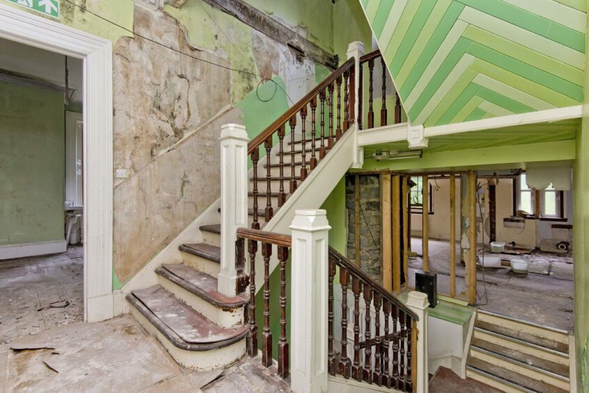 Dunolly House interior showing peeling wallpaper and stairs