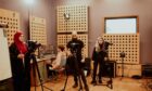 Students studying digital media and technologies courses at Fife College with film equipment in a studio.