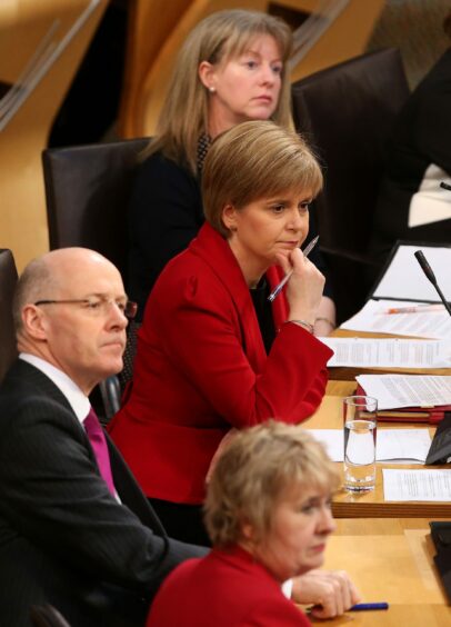Shona Robison seated next to Nicola Sturgeon in the Scottish Parliament.
