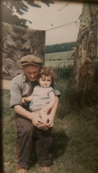 The writer as a toddler on her grandfather's knee.