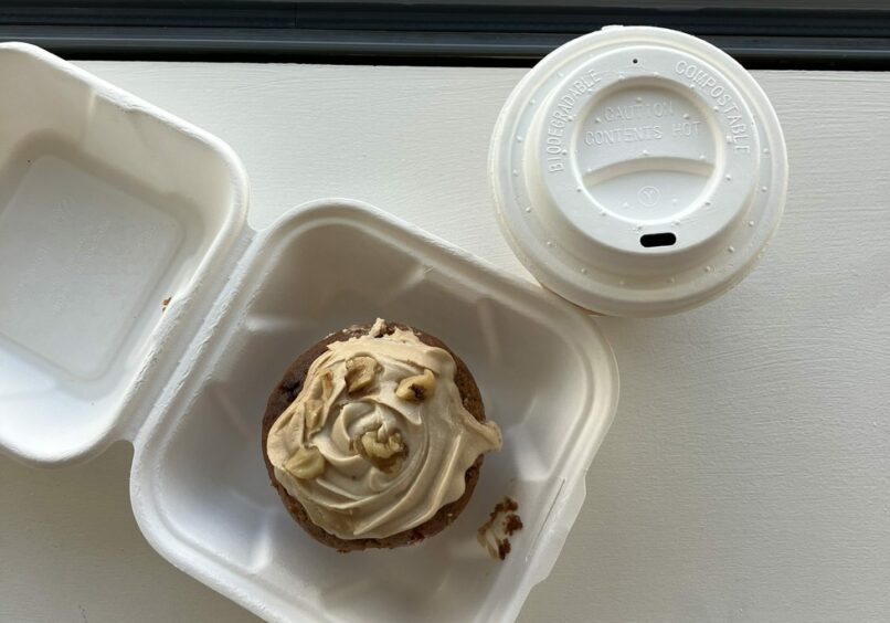 A white takeaway box with a muffin next to a takeaway cup from ReBoutique.