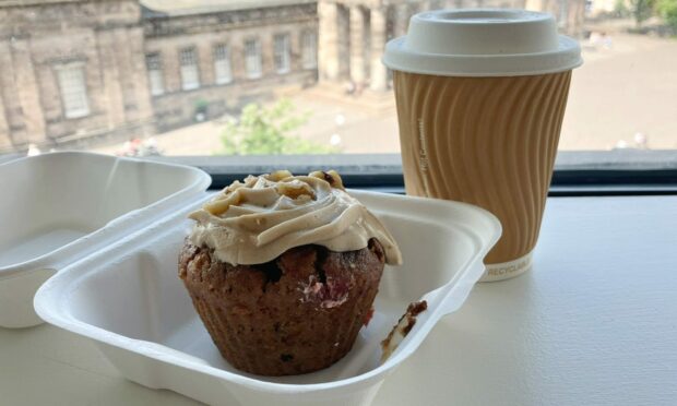 A muffin with frosting and takeaway cup of tea from ReBoutique.