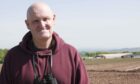 John Bell, member of the Cononsyth Protest Group in front of the farm.