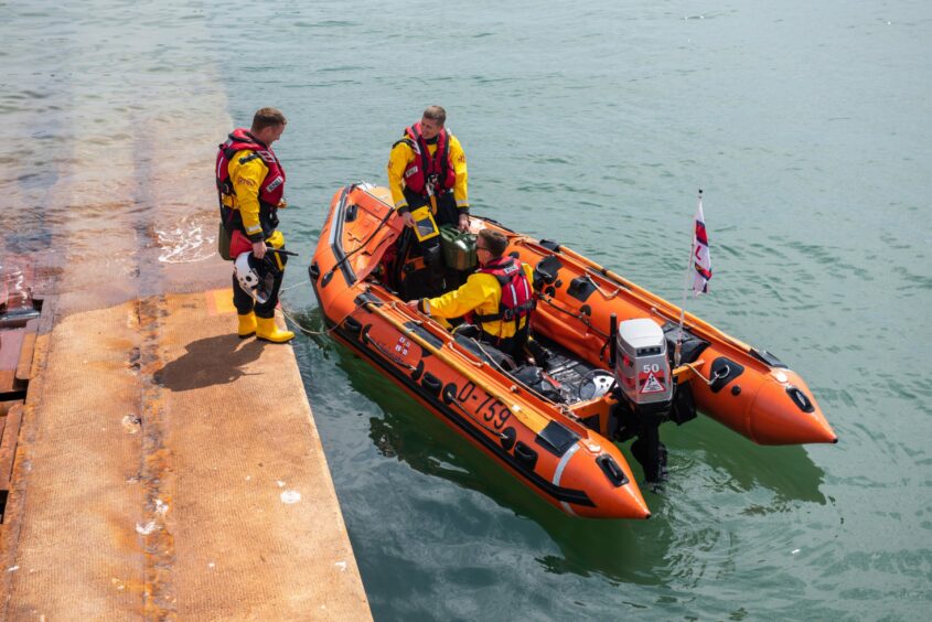 Crew with the current D-class Robert Fergusson inshore lifeboat. Image: Kim Cessford/DC Thomson.