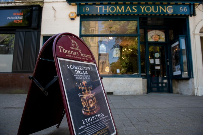 The shop exterior and a board promoting the clock exhibition in Cupar. 