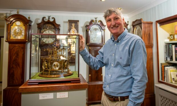 Eric Young in his shop with the display of clocks, Image: Kim Cessford/DC Thomson