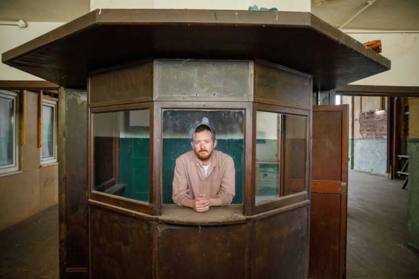 Musician Andy Truscott is pictured inside the box office of an abandoned cinema/dance hall in Crail.