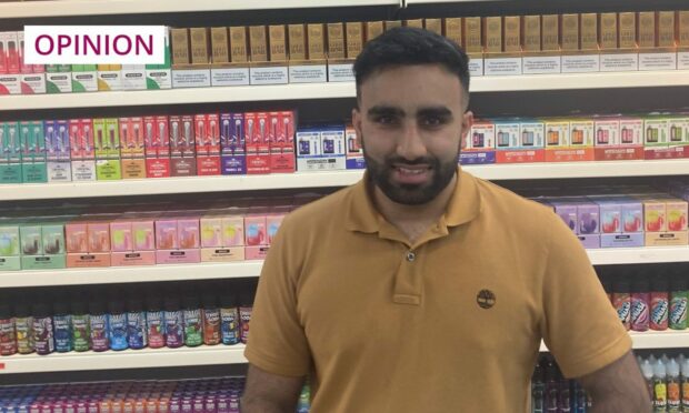 Hussain Ahmed in his shop in Dundee's Murraygate, in front of a display of disposable vape devices.