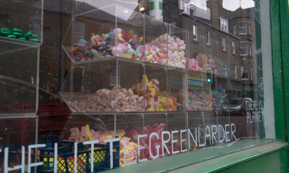 See-through boxes of pick and mix sweets on display in The Little Green Larder's window.