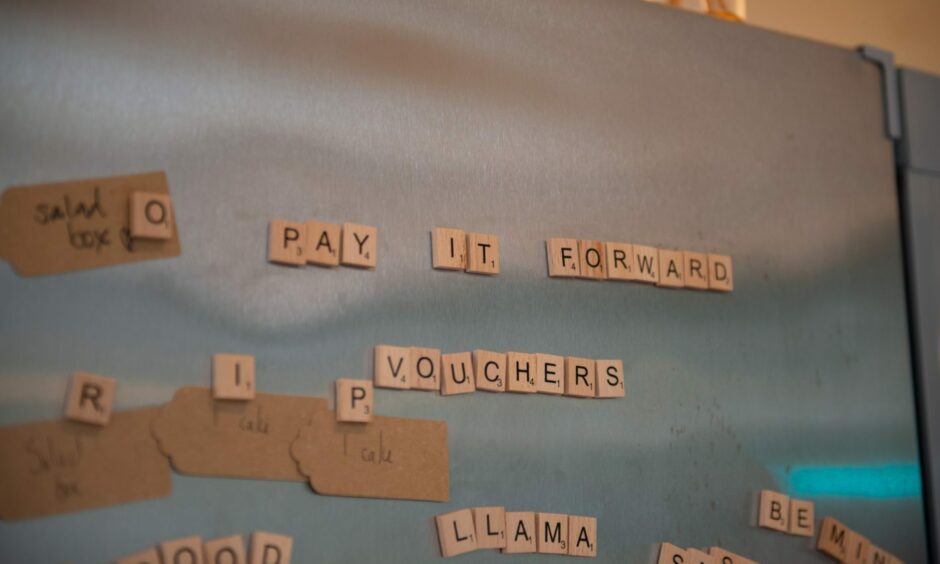 Magnets spelling out pay it forward vouchers.