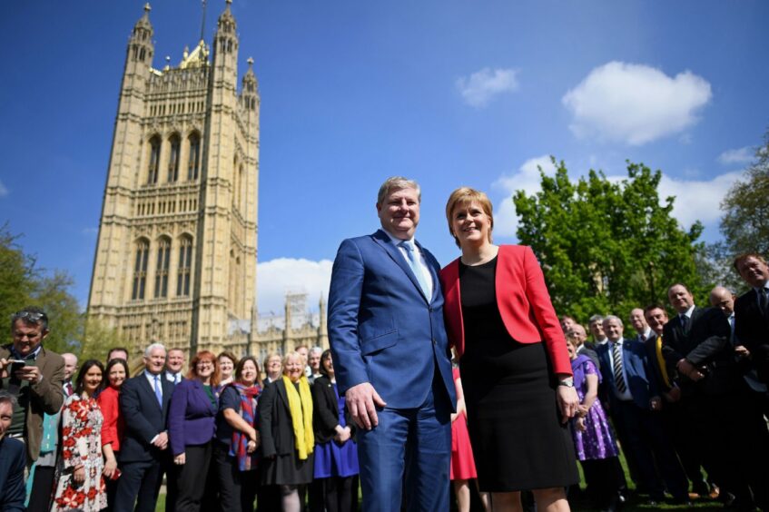 Former SNP Westminster leader Angus Robertson and former First Minister and SNP leader Nicola Sturgeon standing outside the Houses of Parliament with the party's MPs in 2017