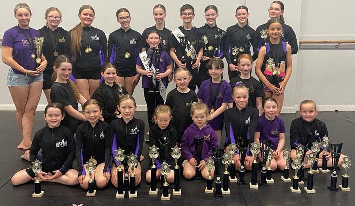 The full Inspire Dance Studio team with the medals and trophies they won at the WLDF.