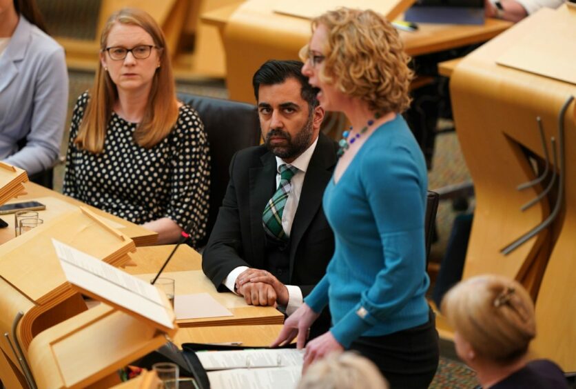 Humza Yousaf looks on as Scottish Greens co-leader Lorna Slater addresses the Scottish Parliament.