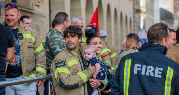 Red watch firefighter Jamie Scott and four-month-old son Theo Scott at the protest outside council headquarters in Perth.