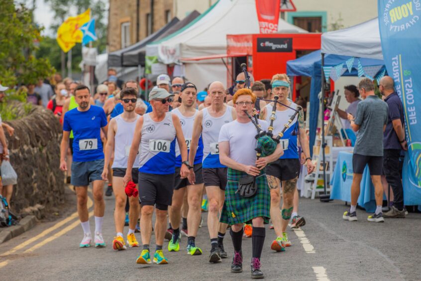 Road runners being piped to the start.