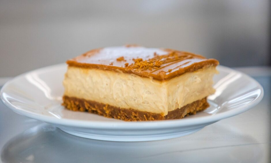 A slice of Biscoff cheesecake sitting on a white plate