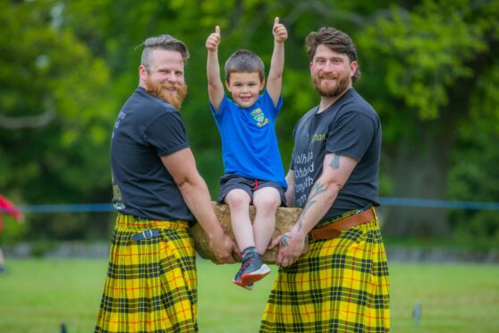 Glamis P1 youngster Sandy McKenzie, 5, gets a lift on the blood stane from Brett Hampton (left) and Nathan Jones from Valhalla Gym in Forfar.  Image: Steve MacDougall/DC Thomson