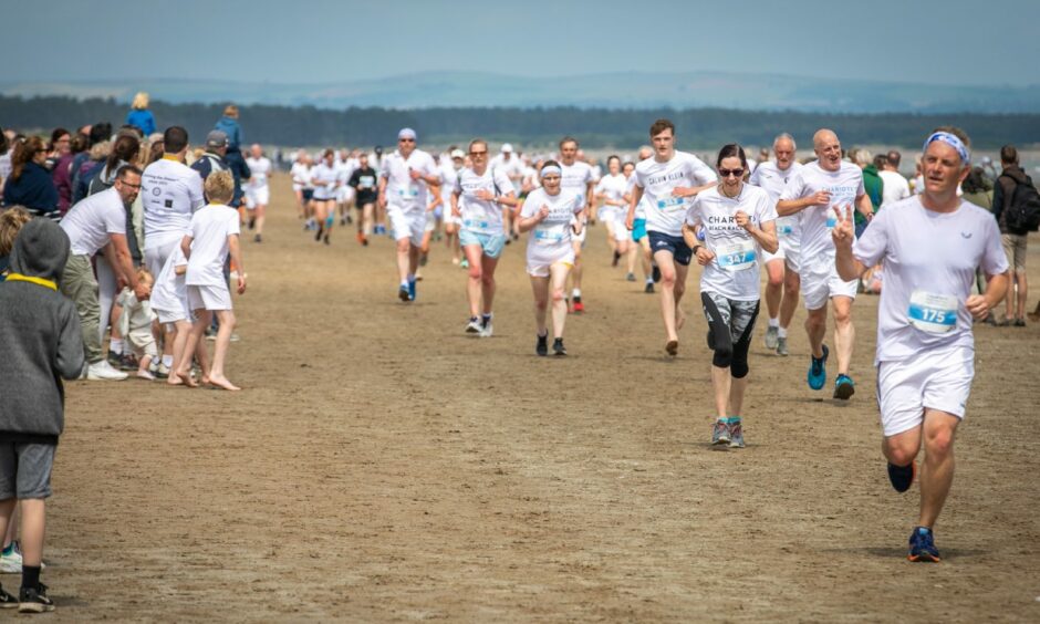Crowds cheer on the runners in the St Andrews Chariots of Fire beach race