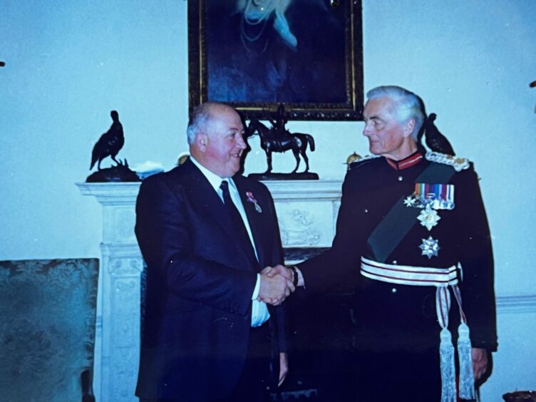 Receiving his BEM, Douglas Matthewson, left, and the Lord Lieutenant of Angus, Lord Airlie.