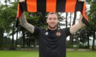 Kevin Holt holds a Dundee United scarf aloft after signing for the Tannadice club.