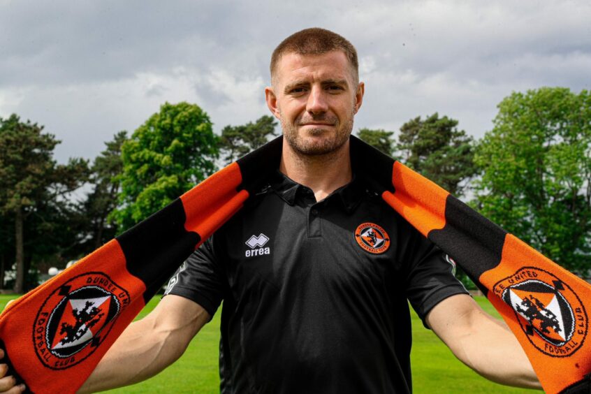 Ross Docherty is pictured with a Dundee United scarf