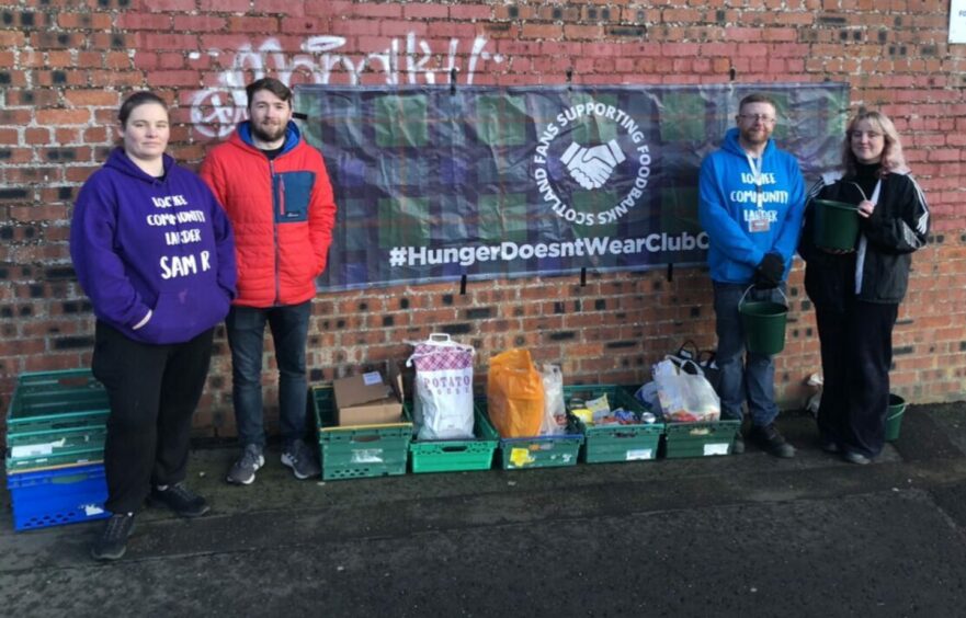 Fans Supporting Foodbanks Dundee volunteers standing outside football stadium with donations. (Left to right) Sam Roberts of Lochee Larder, Darren Thomson, co-founder of Fans For Foodbanks Dundee, Dave McGregor of Lochee Larder and Fiona Orr of Dundee University Socialists Society.