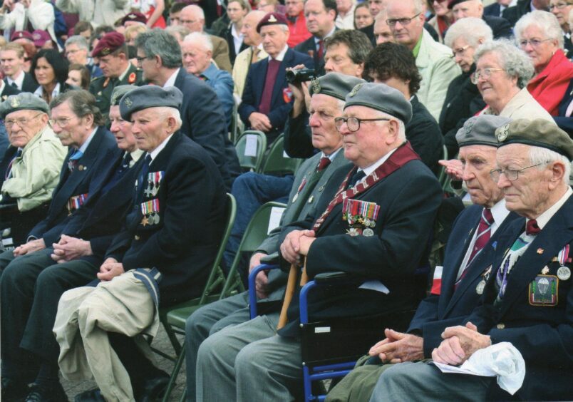 Polish paratrooper anniversary - Stan Kulik sits with a cream jacket on his lap.