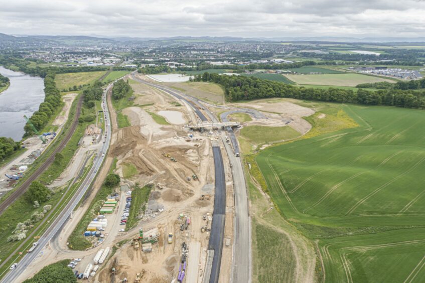 Aerial photo showing long stretch of road works with Perth in distance