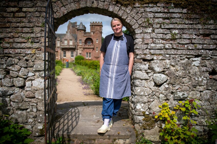 Chef Elaine standing in an archway in the Hospitalfield gardens.