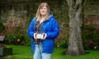Rosie Gilbert-Virk with the photograph of her dad in the Springfield Park Rose Garden, Arbroath. Image: Kim Cessford/DC Thomson