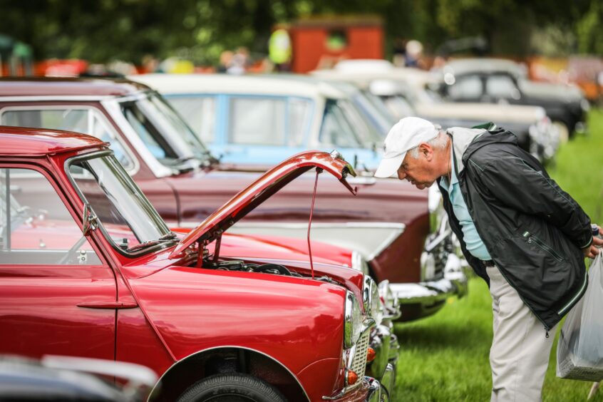 A visitor marvelling at a Mini in the grounds of Glamis. Image: Kris Miller/DC Thomson.