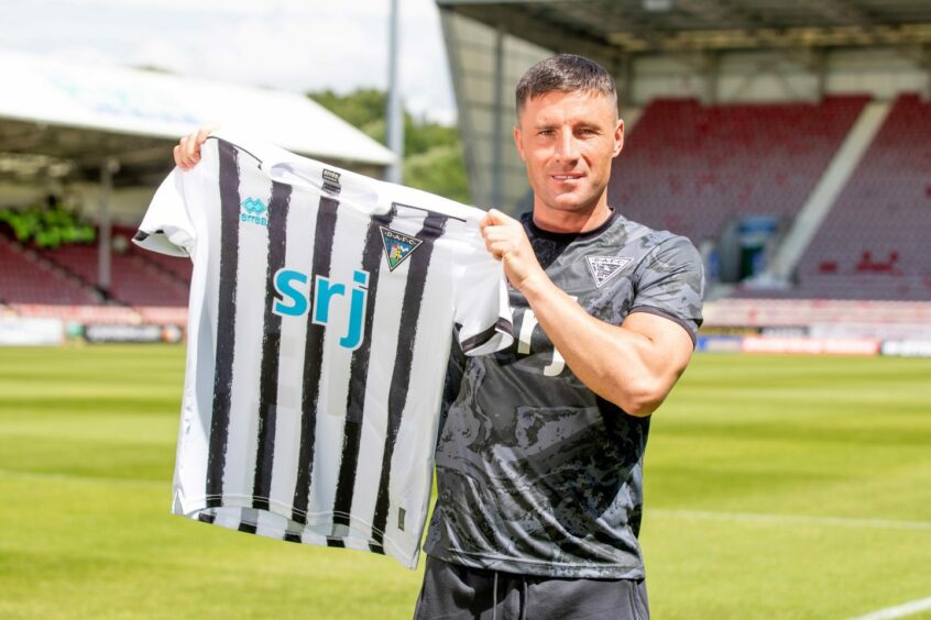 Michael O'Halloran holds up a Pars shirt at East End Park after signing a two-year deal at Dunfermline Athletic. Image: Craig Brown/DAFC.
