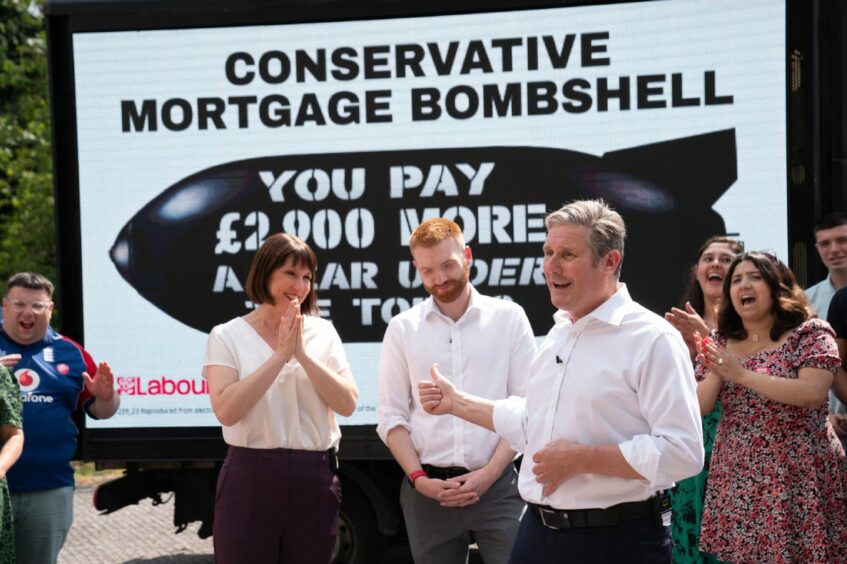 Labour leader Sir Keir Starmer and shadow chancellor Rachel Reeves with candidate Danny Beales, who is trying to win the Uxbridge and South Ruislip seat formerly held by Boris Johnson. They are standing in front of a poster with the slogan 'Conservative mortgage bombshell' while supporters applaud.