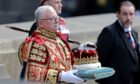 Lord Lyon King of Arms Joseph Morrow carrying the Crown, which forms part of the Honours of Scotland, at St Giles' Cathedral. Image: Chris Jackson/PA Wire.