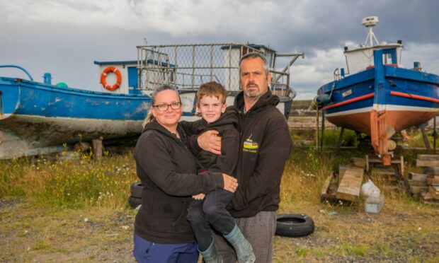 Tina and Ross Coventry and son James in front of boats in Methil